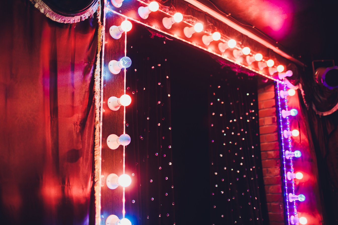 Light Bulbs On Stage Theatrical scene with colored glitter neon bulbs for presentation or concert performance. Night show in festive evening.